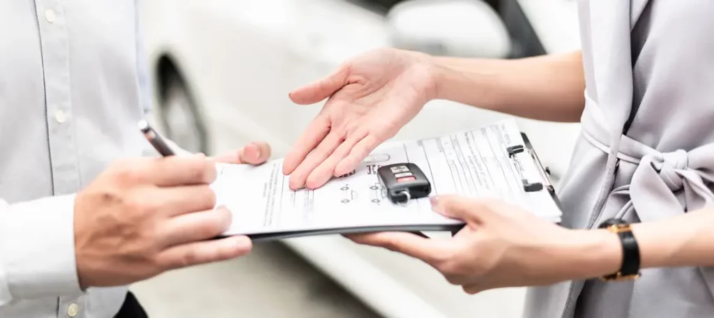 Übergabe von Fahrzeugschlüsseln und Vertragsunterlagen bei einem Autoverkauf im EU-Binnenhandel – Symbolbild für innergemeinschaftliche Lieferung steuerfrei.