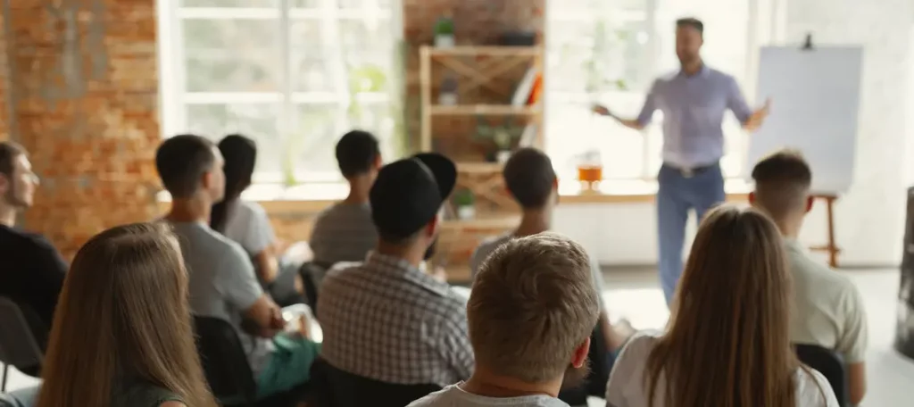 Dozent hält Seminar vor einer Gruppe Erwachsener – Symbolbild für Bildungsleistungen und Schulungen im Rahmen der Umsatzsteuerbefreiung nach § 4 Nr. 21 UStG.