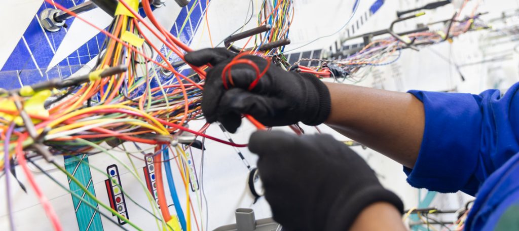 Handwerker hantiert mit verschiedenen Kabeln. Symbolbild für Umsatzsteuer und Tooling