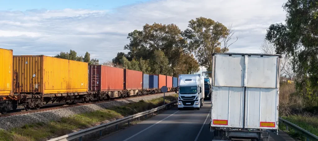 Lkw und Containerzug transportieren Waren parallel – Symbolbild für Versandlieferung und Lieferortbestimmung nach § 3 Abs. 6 UStG.
